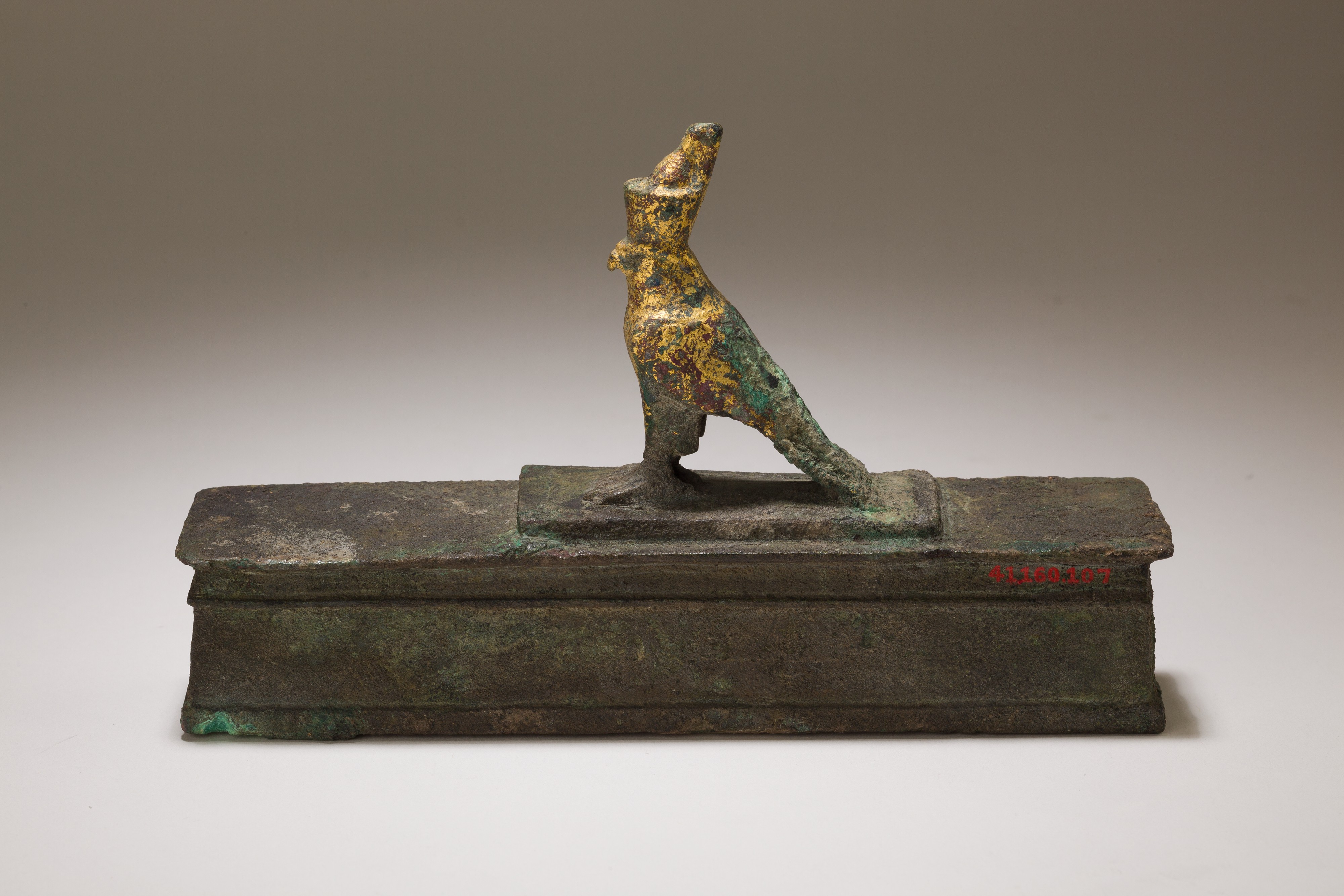 Falcon in double crown surmounting a shrine shaped box for an animal mummy