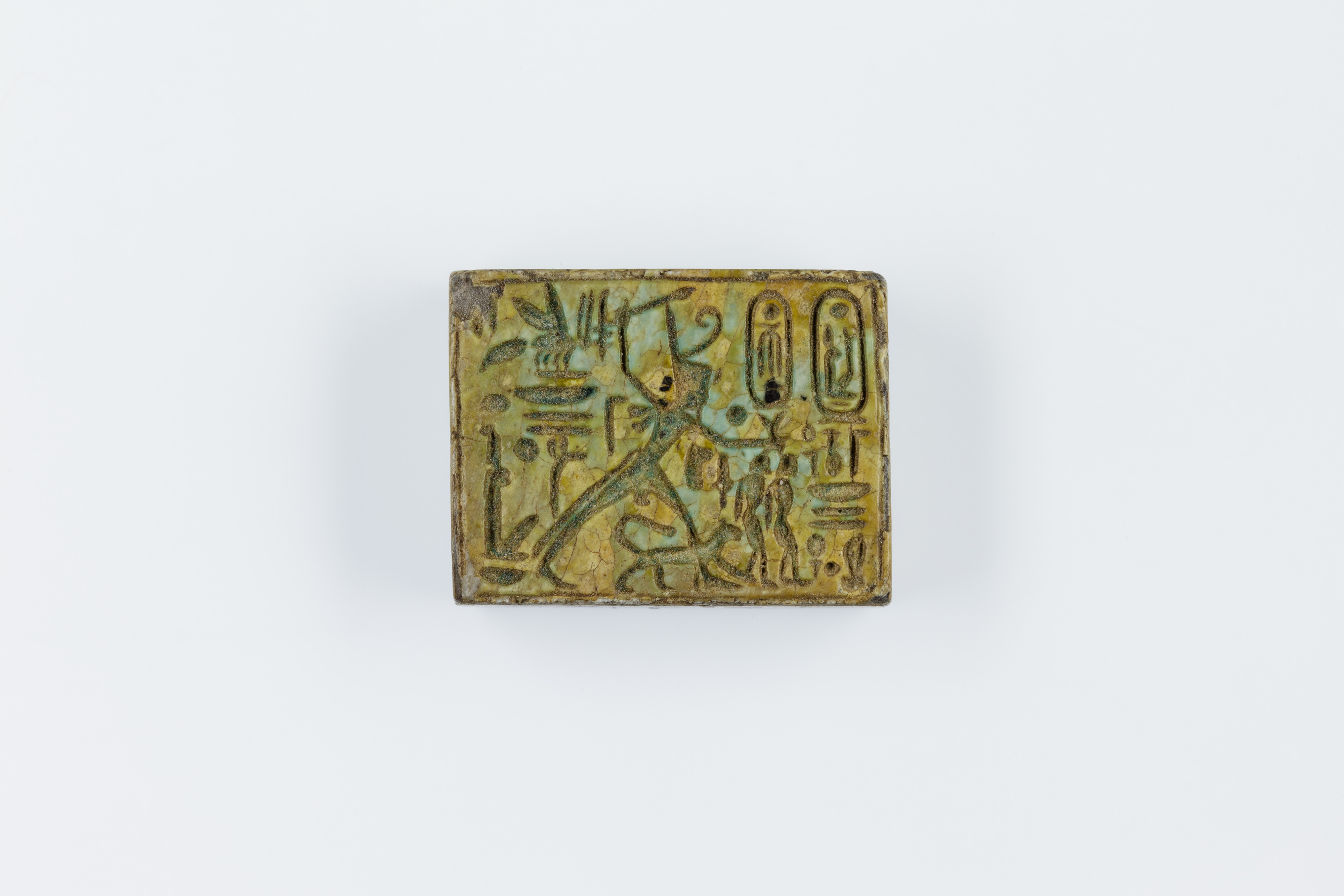 Oblong Plaque Depicting Ramesses II Smiting Enemies, opposite side relief scene of Isis and Nephthys flanking falcon labeled Horus son of Isis