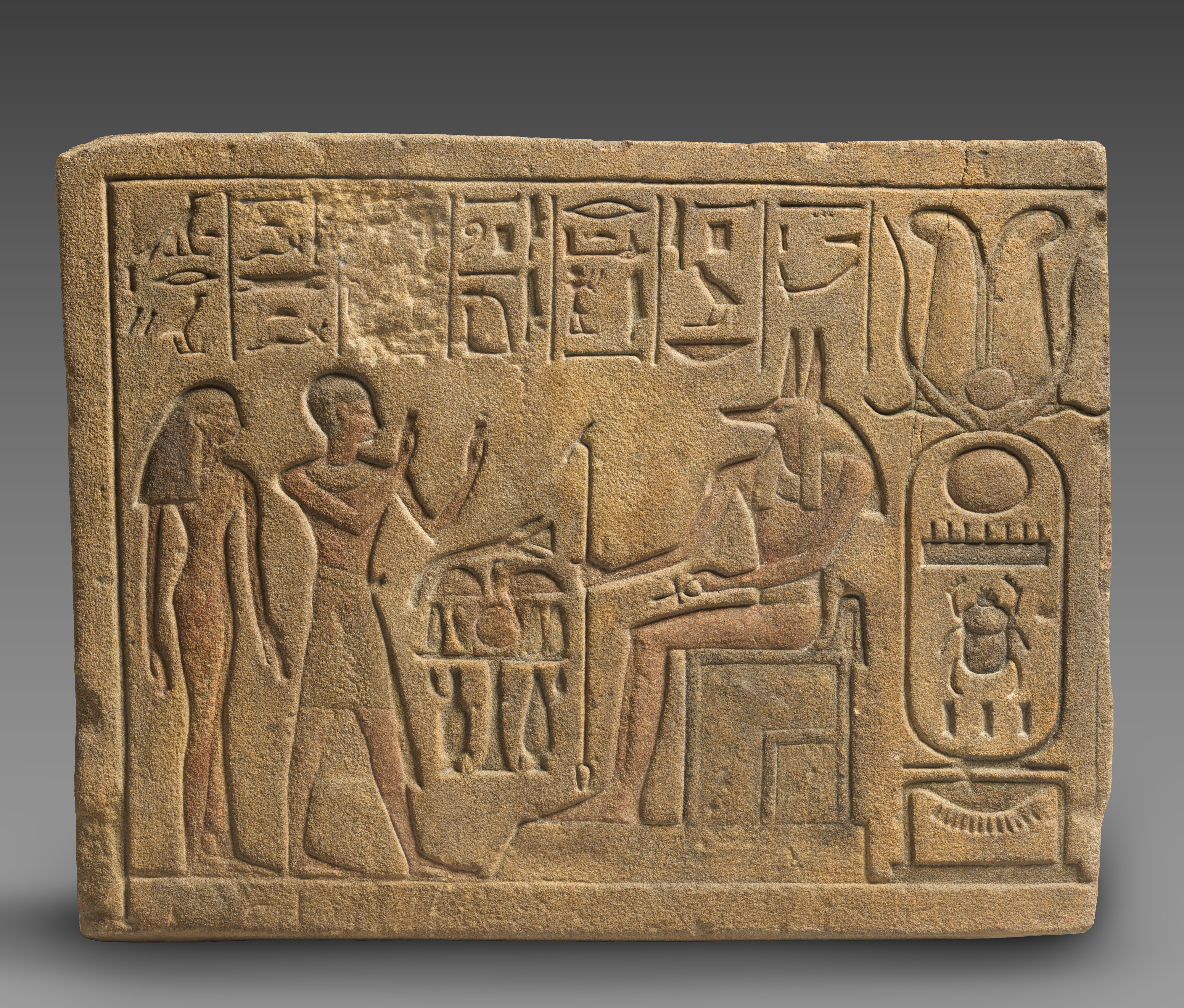 Relief showing a priest and a woman worshipping Anubis