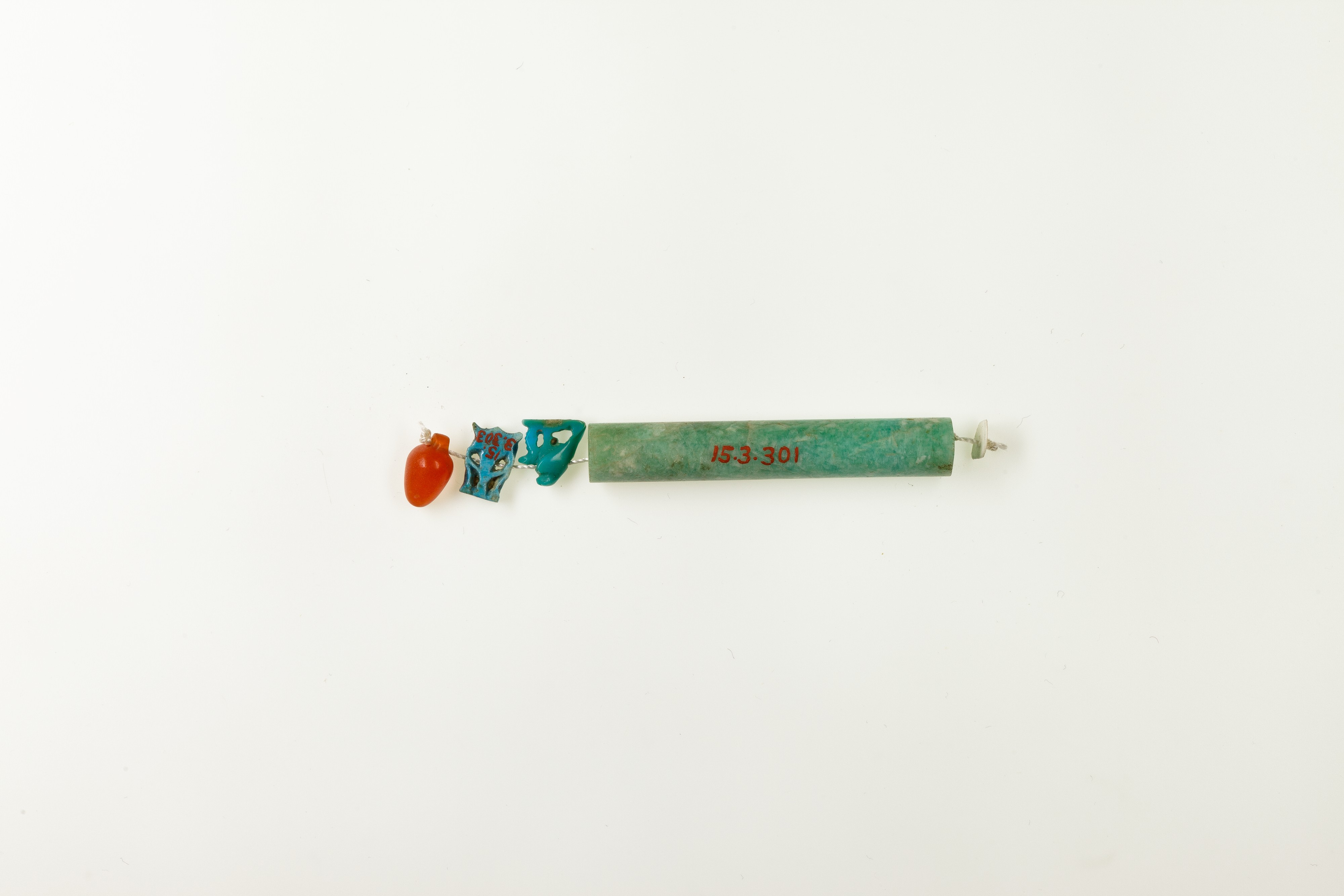 String of 3 amulets and 1 cylindrical bead