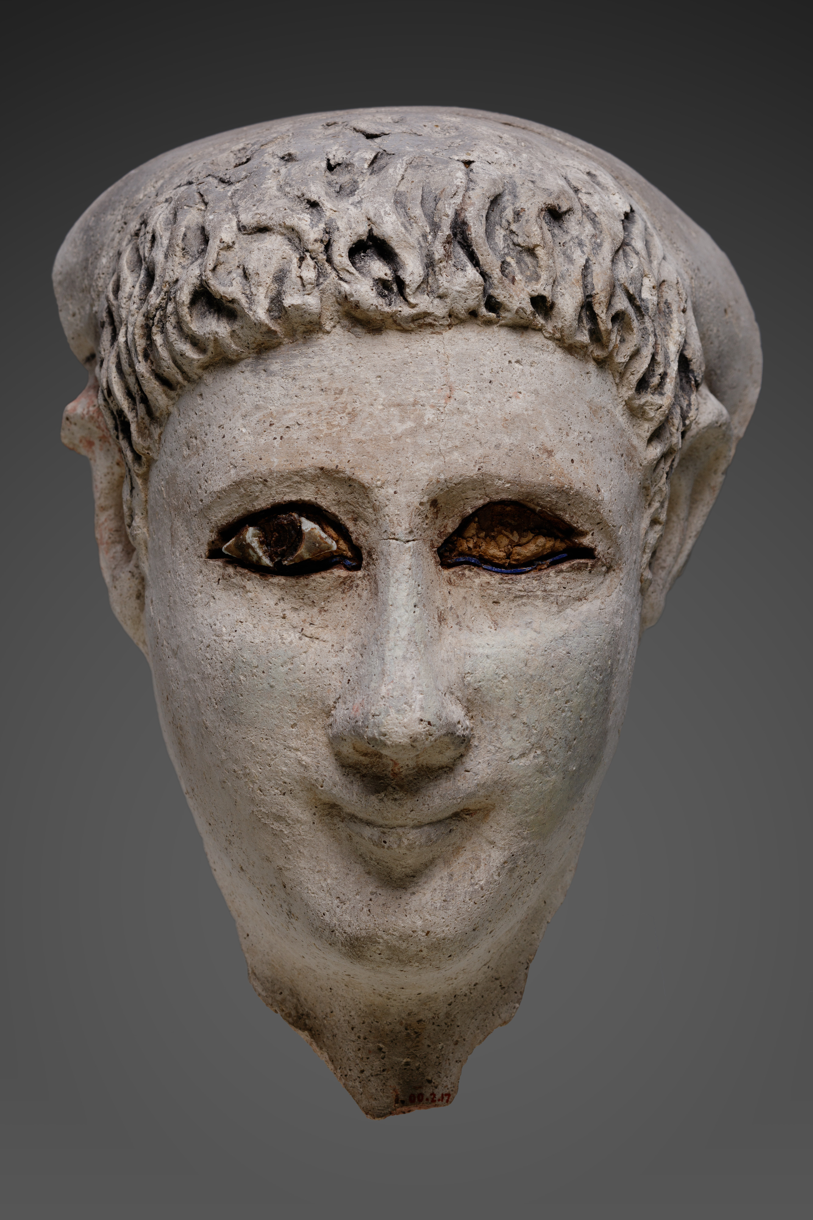 Mask of a man with loose hair combed forward and a mantle