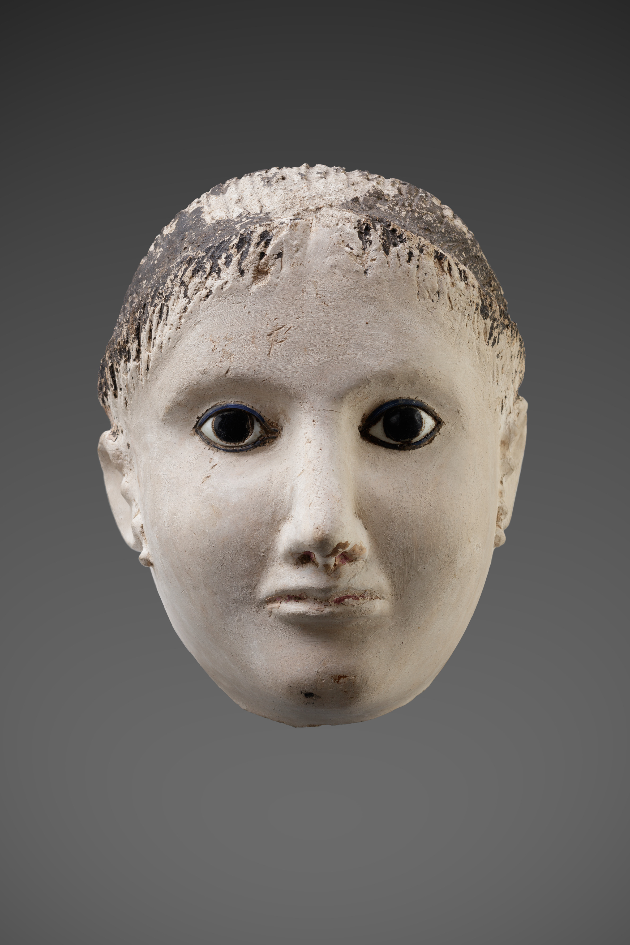 Mask of a woman with her hair rolled back at the forehead and temples