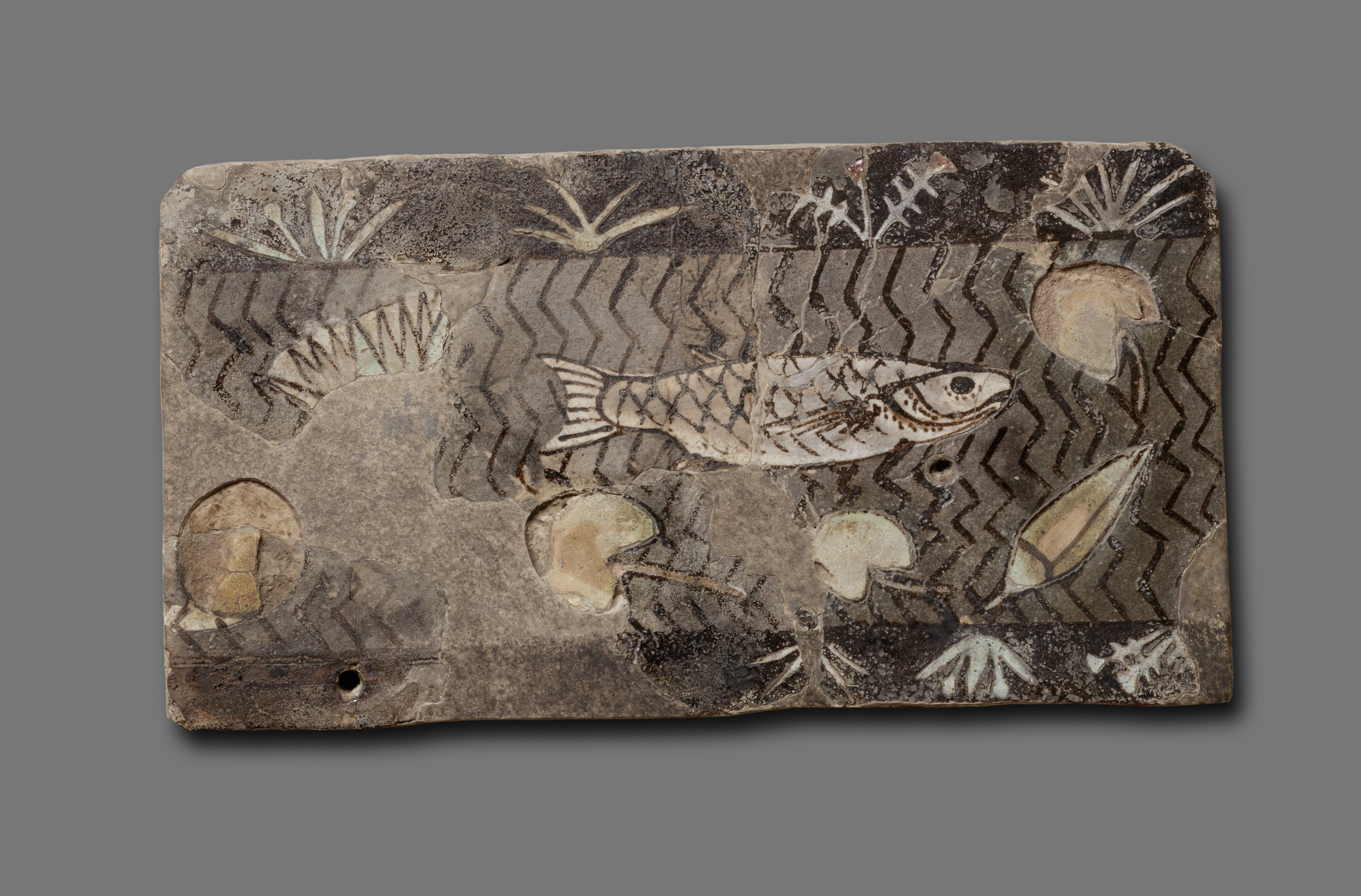 Tile with fish and lotus flowers in a canal