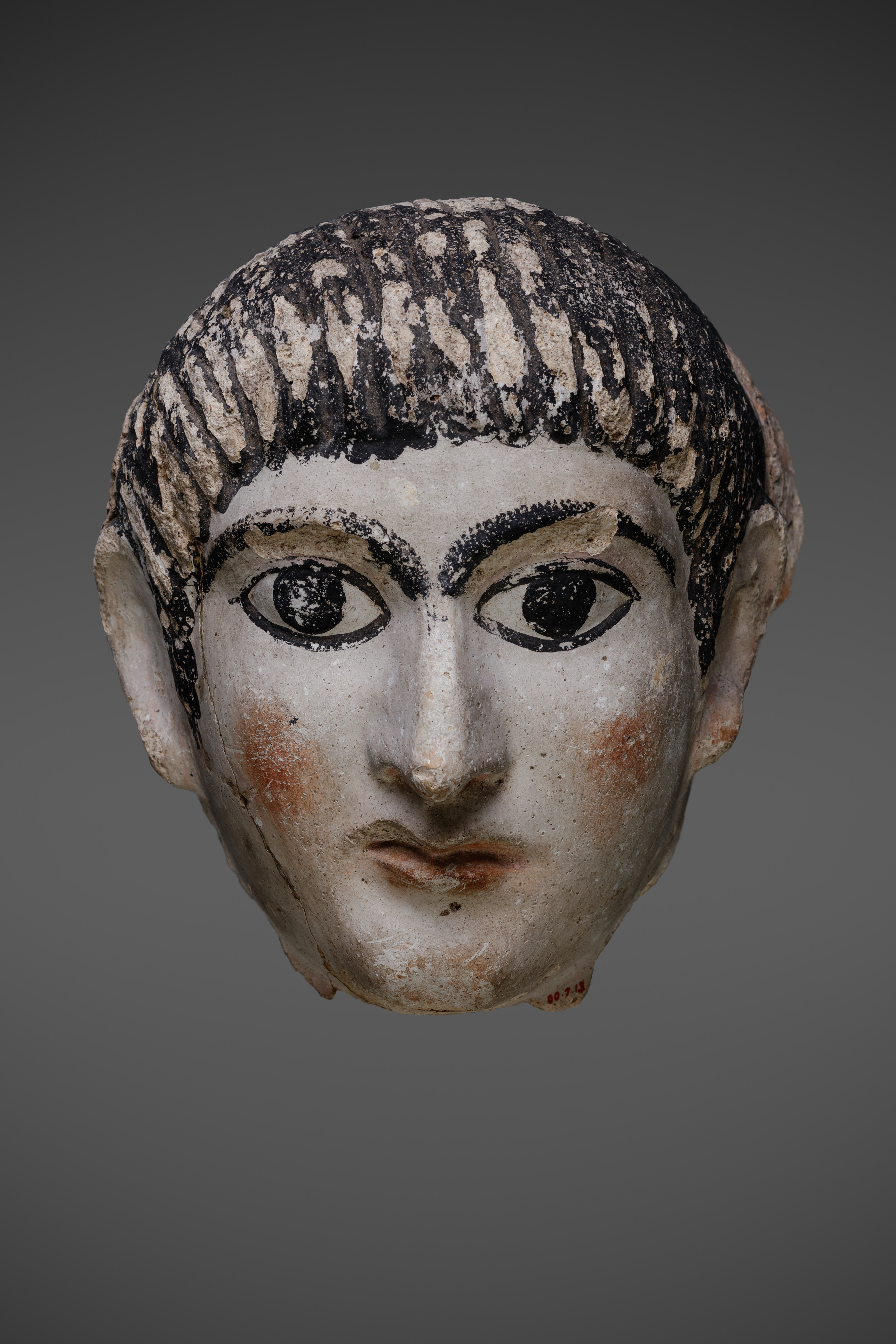 Mask of a man with hair combed forward and a mantle