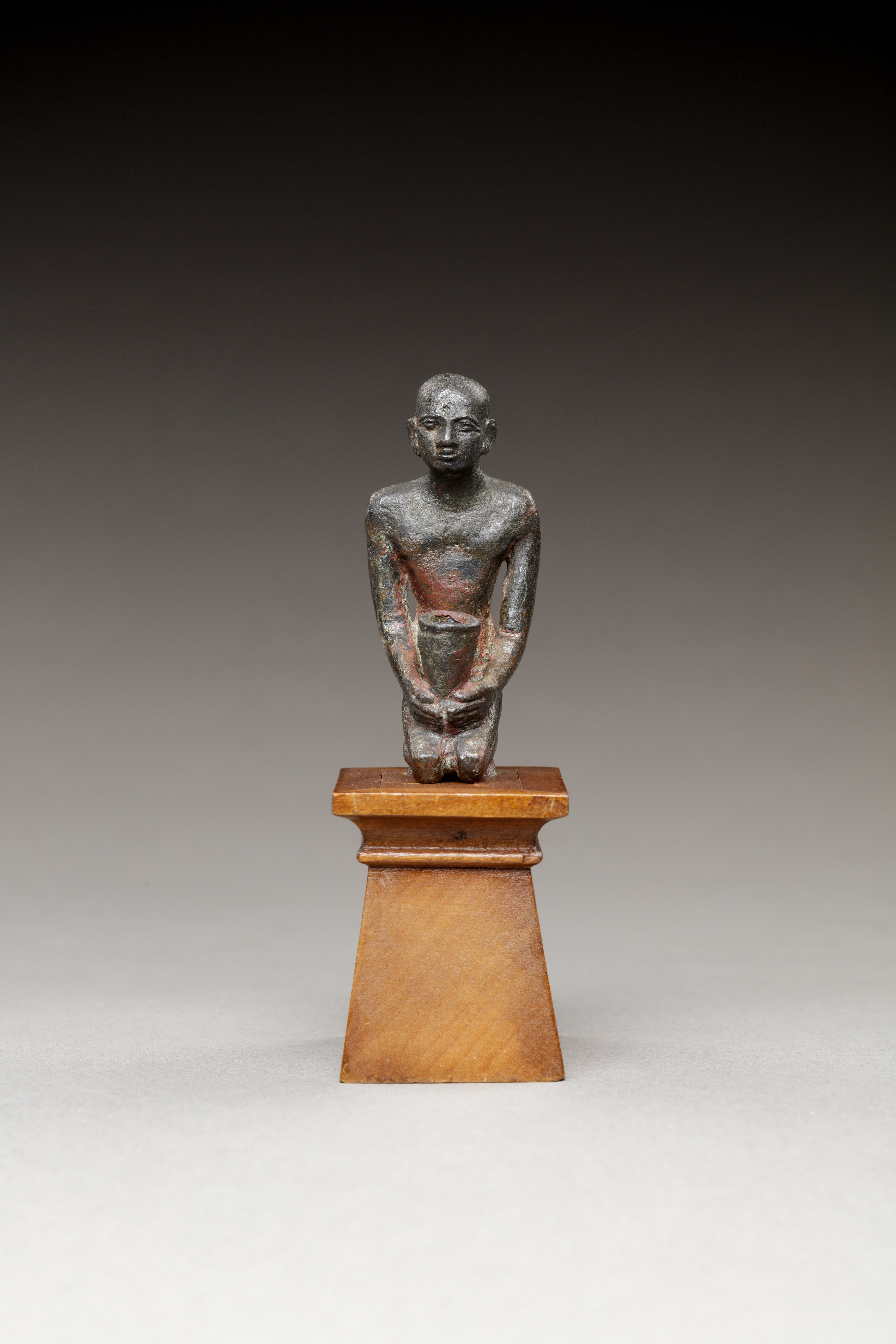 Pediusir kneeling, holding a jar